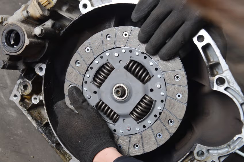 Close-up of a manual transmission gearbox and dual-mass flywheel gearing assembly in the garage